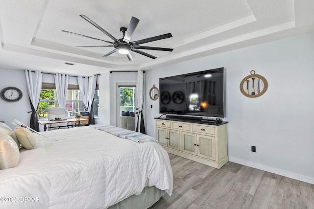 30 Bay Ct, Ormond Beach, FL 32174 - bedroom with a tray ceiling, light wood finished floors, and a ceiling fan