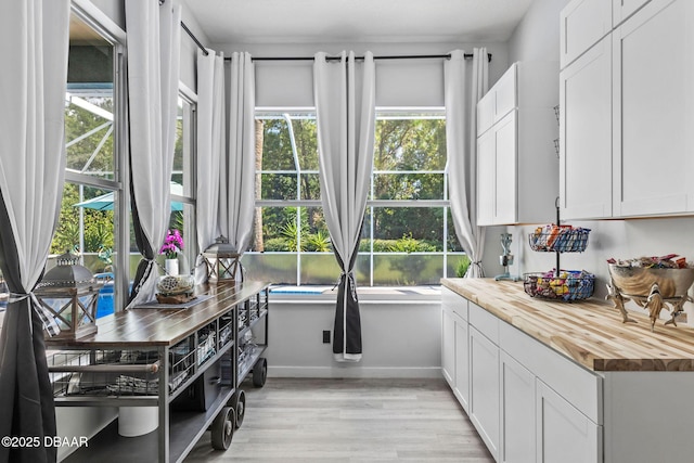 30 Bay Ct, Ormond Beach, FL 32174 - kitchen with butcher block counters, light wood-type flooring, and white cabinetry