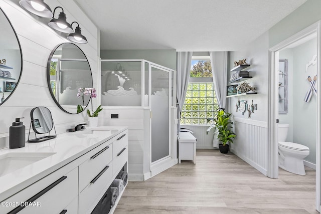 30 Bay Ct, Ormond Beach, FL 32174 - bathroom featuring a stall shower, double vanity, wood finished floors, and wainscoting