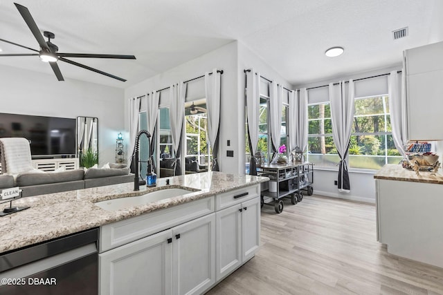 30 Bay Ct, Ormond Beach, FL 32174 - kitchen featuring dishwashing machine, a ceiling fan, open floor plan, light wood finished floors, and light stone countertops