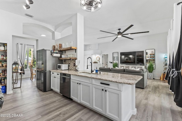 30 Bay Ct, Ormond Beach, FL 32174 - kitchen featuring appliances with stainless steel finishes, ceiling fan, a peninsula, open shelves, and light wood-type flooring