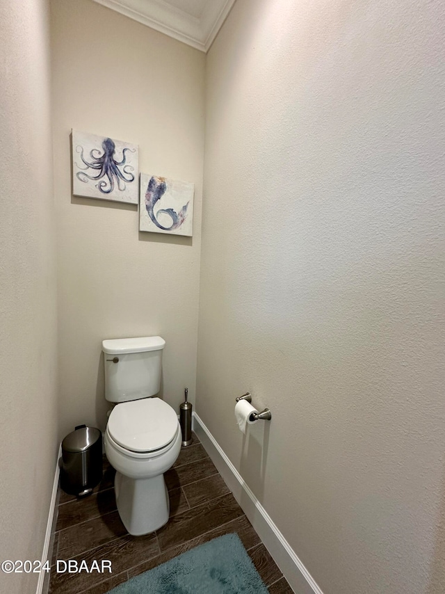 bathroom featuring hardwood / wood-style floors, toilet, and ornamental molding