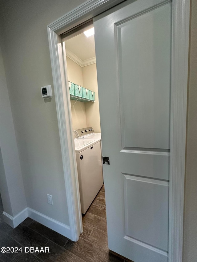 laundry area featuring washing machine and dryer, dark hardwood / wood-style floors, and crown molding