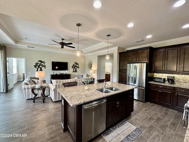 kitchen with sink, stainless steel appliances, dark hardwood / wood-style flooring, crown molding, and a center island with sink