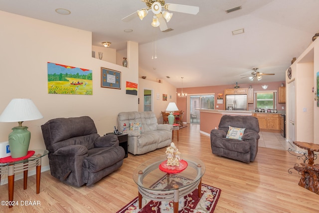 living room featuring ceiling fan with notable chandelier, light hardwood / wood-style floors, and lofted ceiling