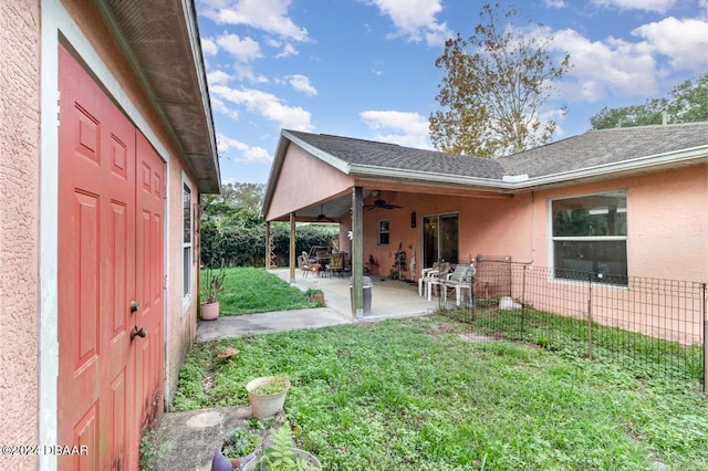 view of yard with ceiling fan and a patio