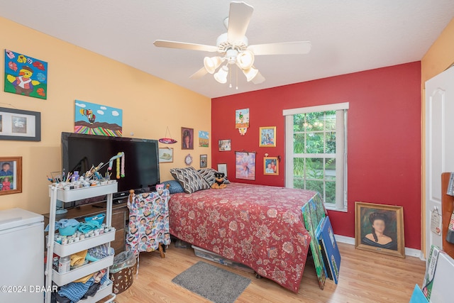 bedroom with ceiling fan and light hardwood / wood-style floors