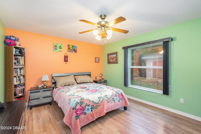 bedroom featuring ceiling fan, a textured ceiling, and light hardwood / wood-style flooring