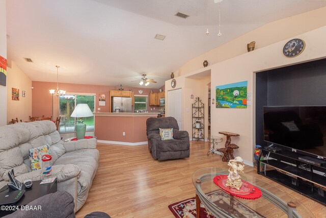 living room featuring ceiling fan with notable chandelier, light hardwood / wood-style floors, and lofted ceiling