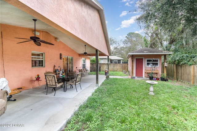 view of yard featuring a storage unit, a patio area, and ceiling fan