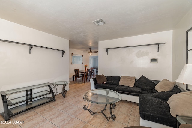 tiled living room featuring ceiling fan and a textured ceiling