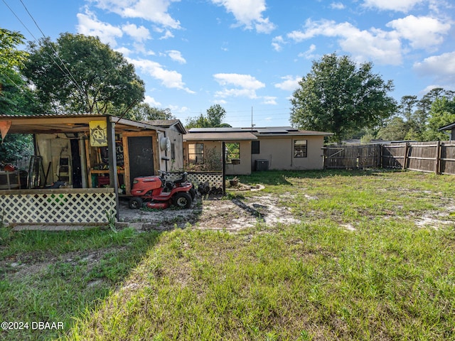 rear view of property with a lawn and cooling unit