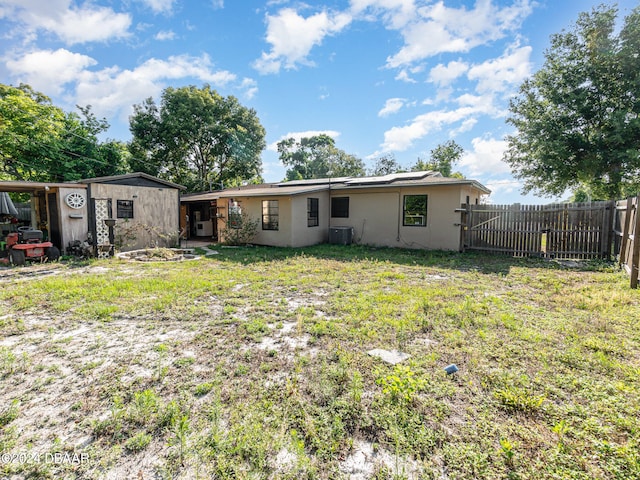 back of property with a lawn and central air condition unit