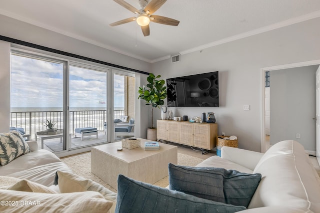 living room with crown molding, ceiling fan, and a water view