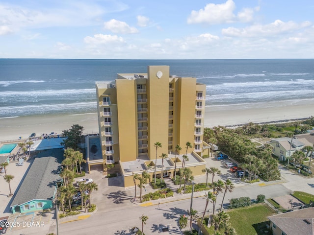 view of property with a water view and a beach view