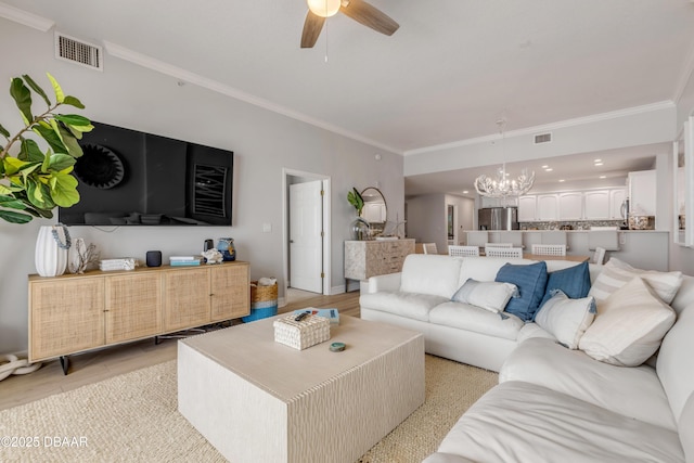 living room featuring ceiling fan with notable chandelier, ornamental molding, and light hardwood / wood-style floors