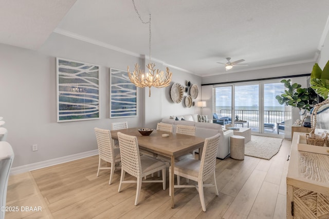 dining area with ornamental molding, ceiling fan with notable chandelier, and light hardwood / wood-style flooring