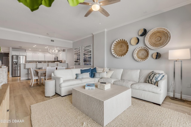 living room with crown molding, ceiling fan with notable chandelier, and light wood-type flooring