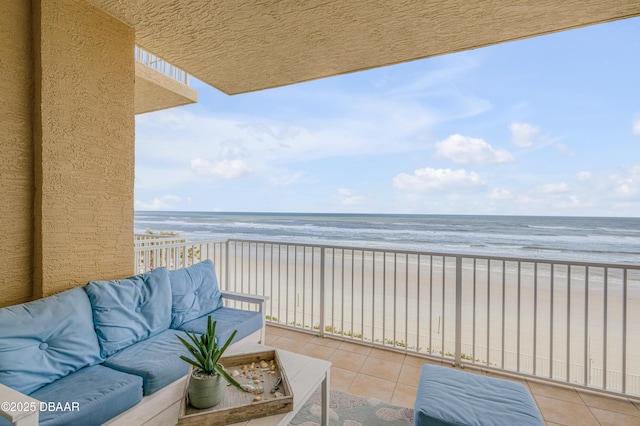 balcony with a view of the beach, outdoor lounge area, and a water view