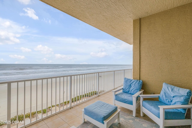 balcony featuring a view of the beach and a water view