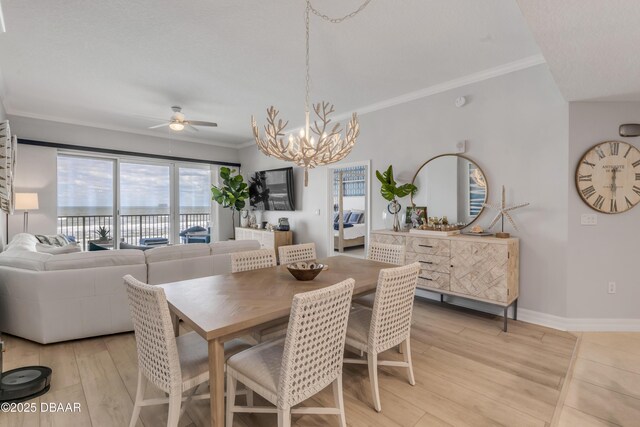 dining space with ceiling fan with notable chandelier, ornamental molding, and light hardwood / wood-style floors