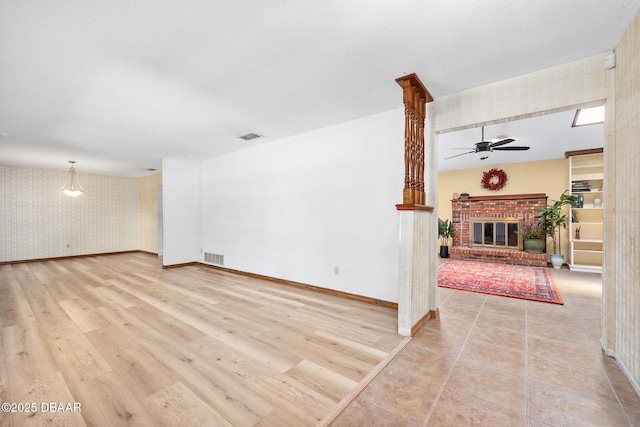 1 River Bluff Ct, Ormond Beach, FL 32174 - unfurnished living room featuring wallpapered walls, a ceiling fan, a fireplace, and wood finished floors