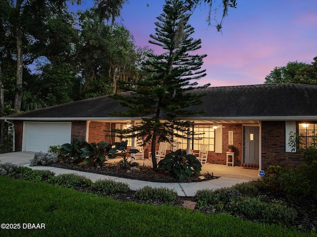 1 River Bluff Ct, Ormond Beach, FL 32174 - view of front of property with brick siding, an attached garage, driveway, and roof with shingles