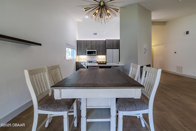210 Sage Brush Trl, Ormond Beach, FL 32174 - dining area with a high ceiling, dark wood finished floors, and a chandelier