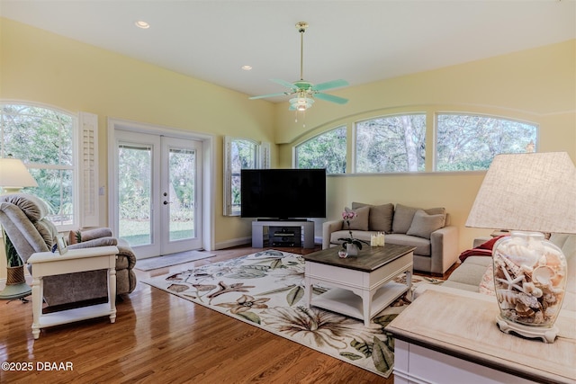 living room featuring hardwood / wood-style flooring, ceiling fan, and french doors