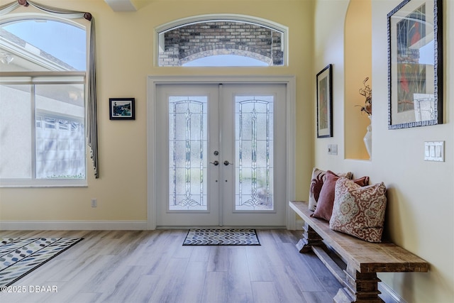 foyer entrance featuring french doors, a healthy amount of sunlight, and light hardwood / wood-style floors