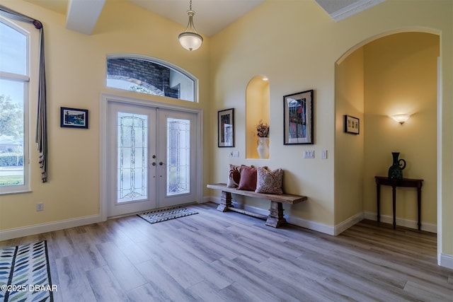 entrance foyer with a high ceiling, light wood-type flooring, and french doors