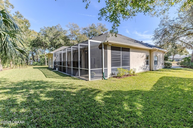 view of side of home with a lawn and glass enclosure