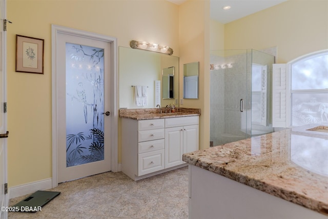 bathroom featuring tile patterned flooring, vanity, and a shower with shower door