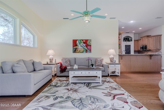 living room with ceiling fan and light wood-type flooring