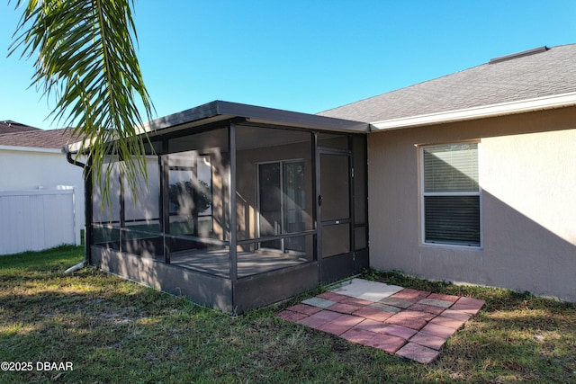 rear view of house with a yard and a sunroom