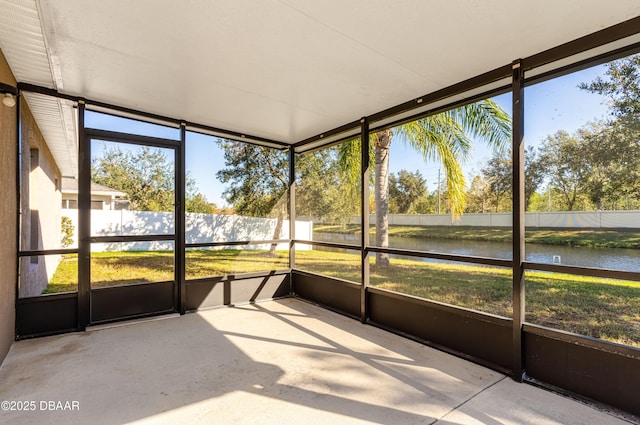 unfurnished sunroom featuring a water view