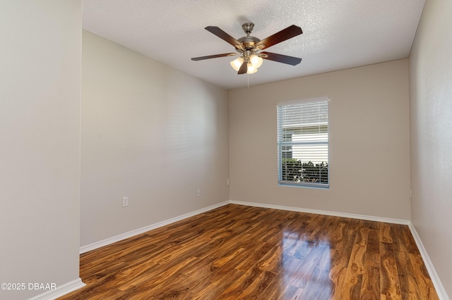 empty room featuring ceiling fan, a textured ceiling, and dark hardwood / wood-style flooring