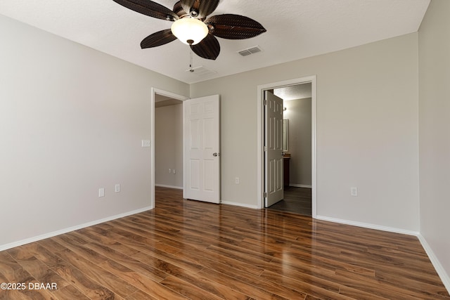 unfurnished bedroom featuring a textured ceiling, dark wood-type flooring, and ceiling fan