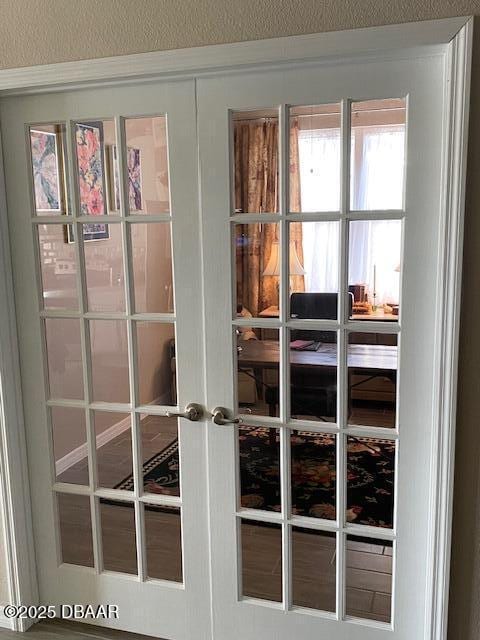 doorway with a textured wall and french doors