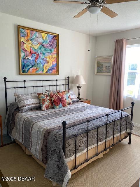 bedroom with a ceiling fan and a textured ceiling