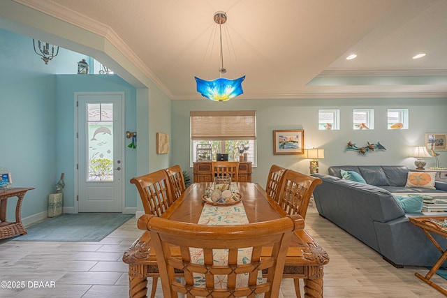 dining space with crown molding and light hardwood / wood-style flooring