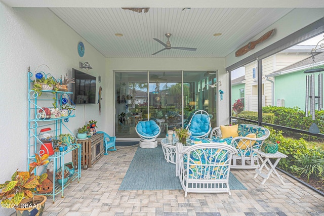 sunroom / solarium featuring ceiling fan