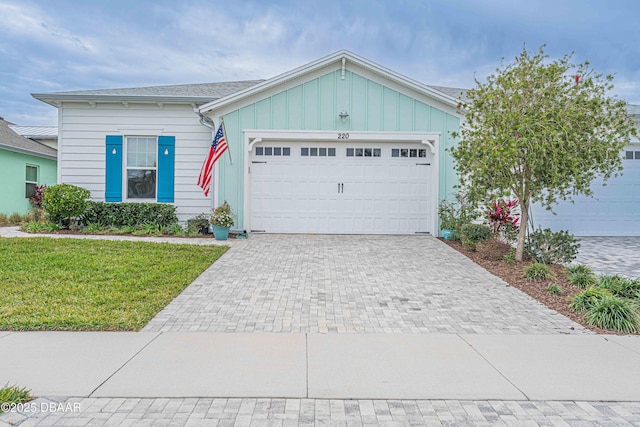 ranch-style home with a garage and a front lawn