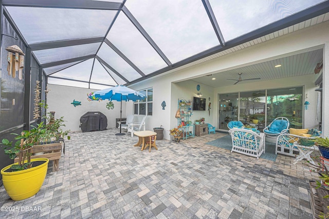 view of patio / terrace with a lanai, ceiling fan, and grilling area