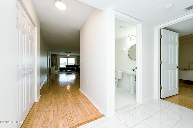 hallway with light hardwood / wood-style floors