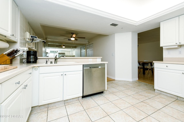 kitchen featuring kitchen peninsula, sink, dishwasher, white cabinetry, and light tile patterned flooring