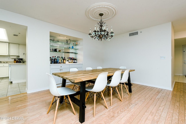 dining area with light hardwood / wood-style flooring and a chandelier