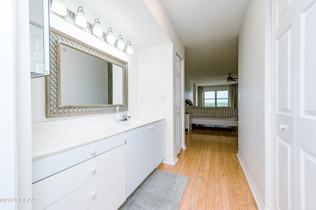 bathroom with ceiling fan, vanity, and hardwood / wood-style flooring