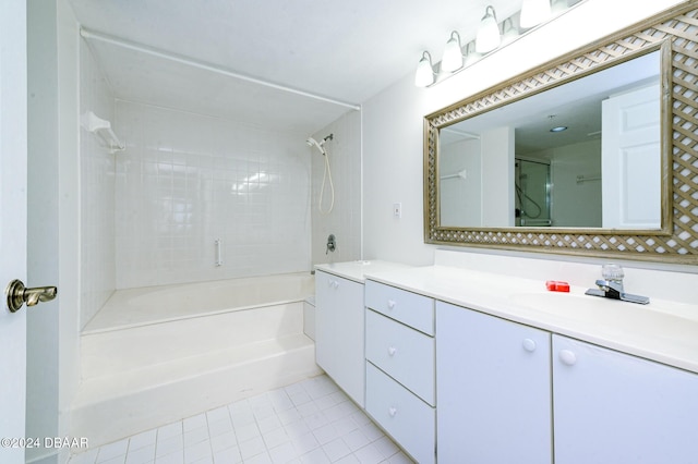 bathroom featuring tile patterned flooring, vanity, and tiled shower / bath combo