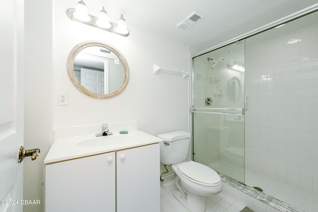 bathroom featuring tile patterned floors, a shower with door, vanity, and toilet